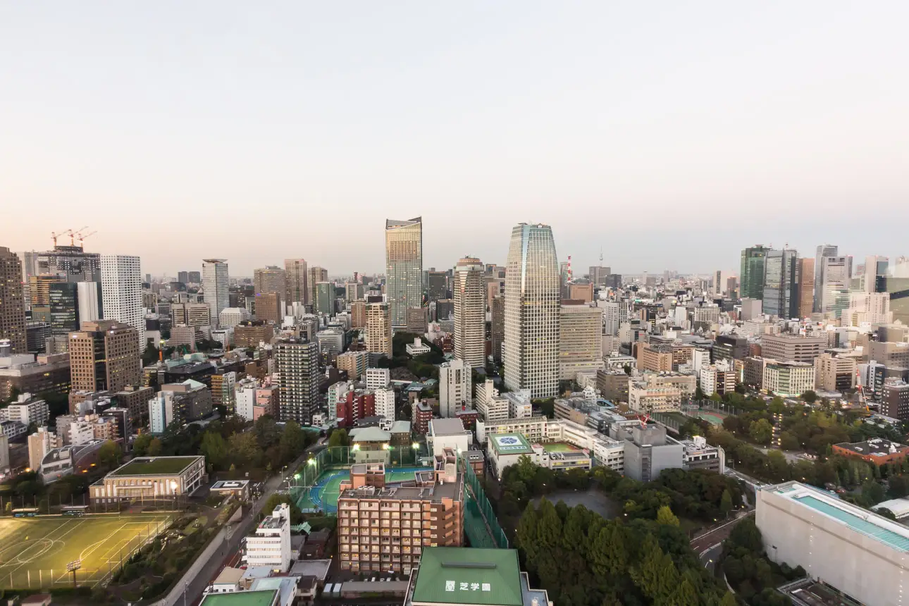 Tokio Stadtpanorama bei Sonnenuntergang Ein Panorama der Stadt Tokio mit vielen Gebäuden und einem Fußballfeld.