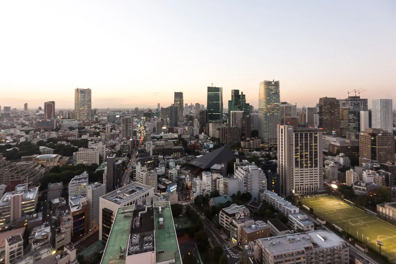Stadtlandschaft bei Sonnenuntergang Eine moderne Stadtlandschaft bei Sonnenuntergang. Die Stadt ist geprägt von hohen Gebäuden und einer lebendigen Atmosphäre.
