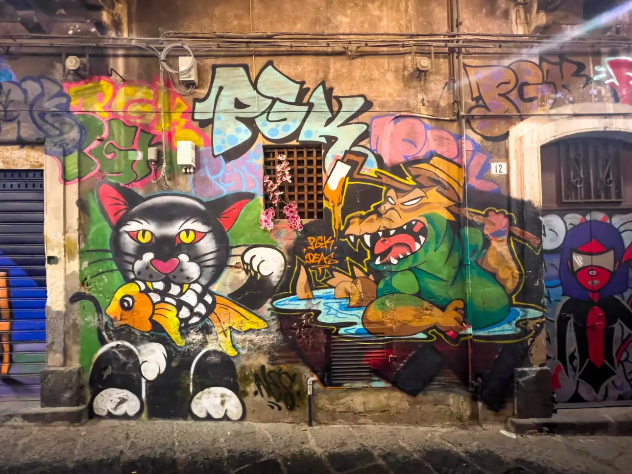 Ein farbenfrohes Graffiti zeigt einen Cartoon-Kater und ein grünes Monster.