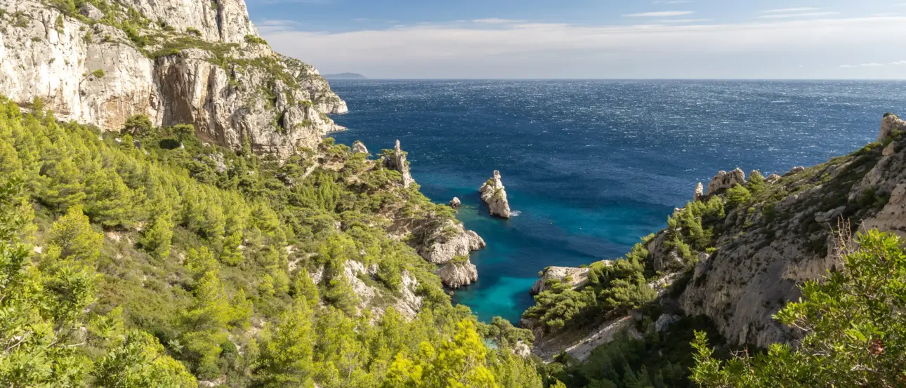 Eine atemberaubende Aussicht auf eine Bucht mit steilen Klippen und türkisblauem Wasser.